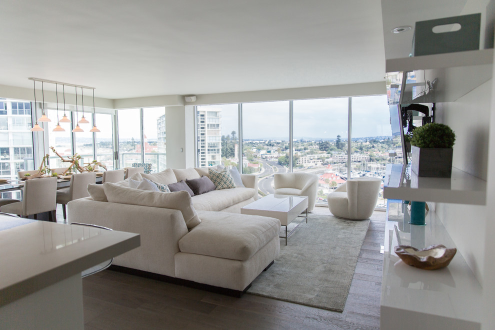 Offenes, Großes Modernes Wohnzimmer ohne Kamin mit hellem Holzboden, weißer Wandfarbe und TV-Wand in San Diego