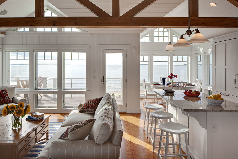 Ejemplo de salón abierto costero de tamaño medio con paredes blancas y suelo de madera clara