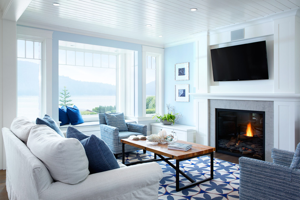 Свежая идея для дизайна: открытая гостиная комната среднего размера в морском стиле с синими стенами, паркетным полом среднего тона, стандартным камином, фасадом камина из плитки, телевизором на стене и коричневым полом - отличное фото интерьера