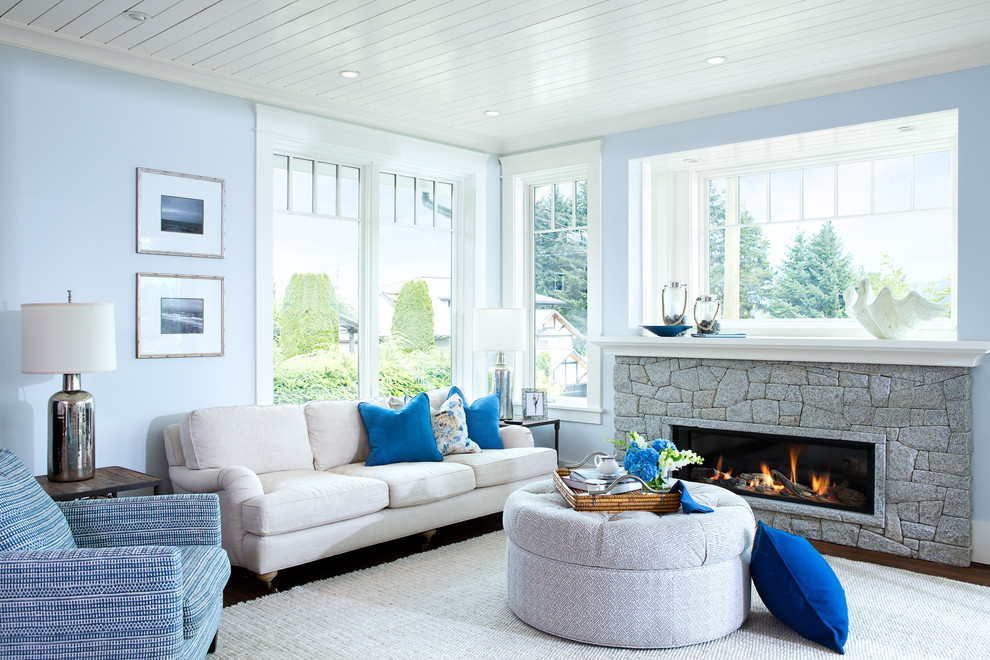Mittelgroßes, Fernseherloses, Offenes Maritimes Wohnzimmer mit blauer Wandfarbe, dunklem Holzboden, Gaskamin und Kaminumrandung aus Stein in Vancouver