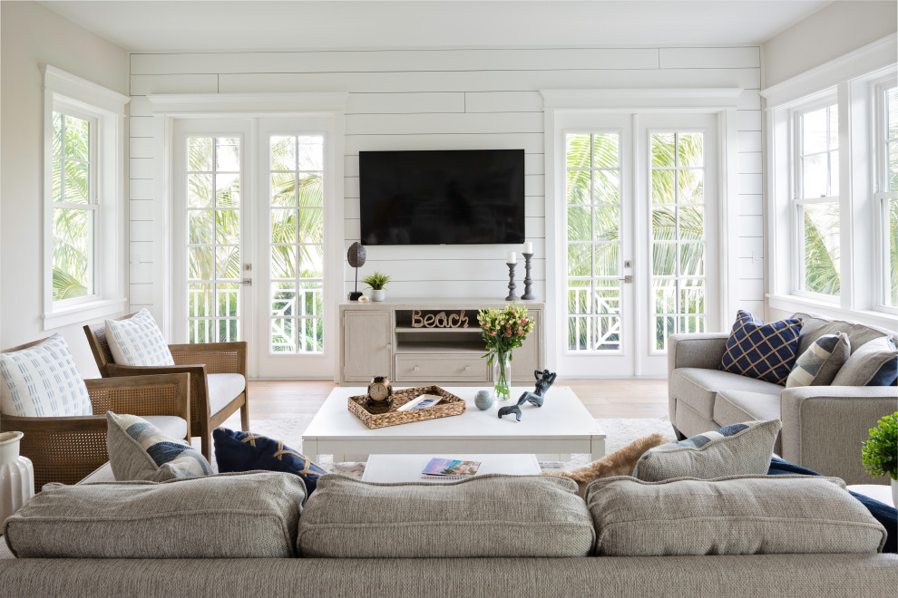 Großes, Offenes Maritimes Wohnzimmer mit weißer Wandfarbe, hellem Holzboden, TV-Wand, beigem Boden und Holzdielenwänden in Tampa