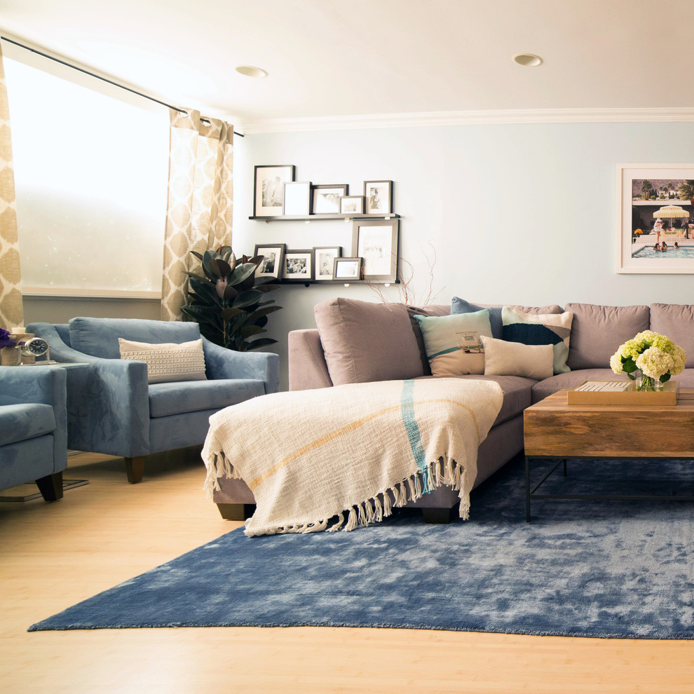 Großes, Offenes Modernes Wohnzimmer mit blauer Wandfarbe, hellem Holzboden, Kamin, Kaminumrandung aus Holz und TV-Wand in Los Angeles