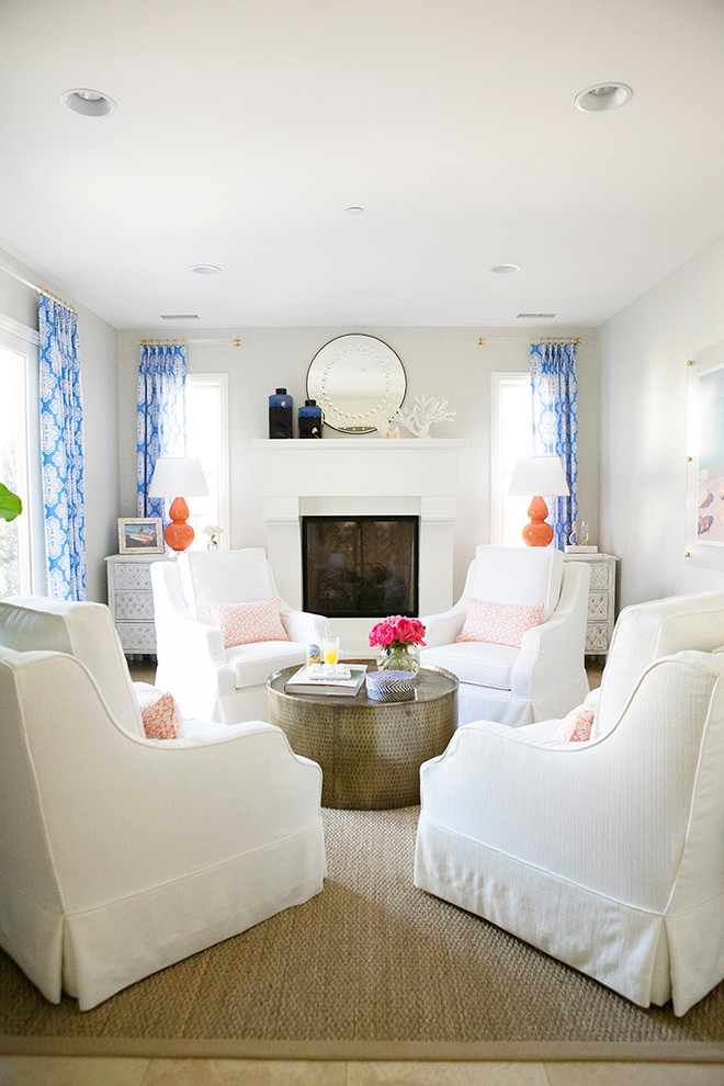 Идея дизайна: гостиная комната в морском стиле с белыми стенами, стандартным камином и синими шторами