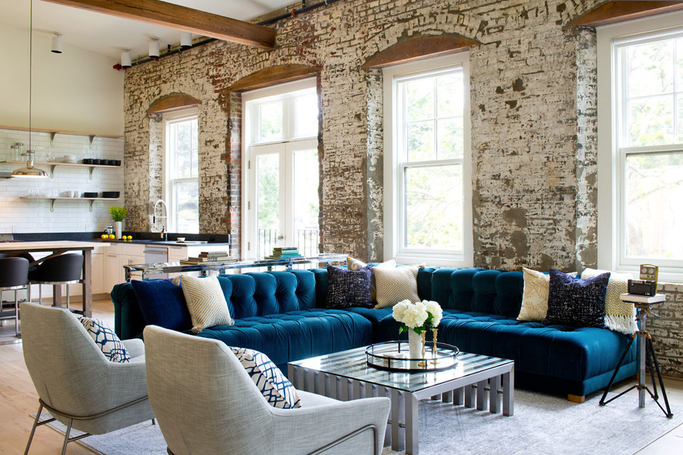 Пример оригинального дизайна: открытая гостиная комната в стиле лофт с бежевыми стенами, светлым паркетным полом и синим диваном