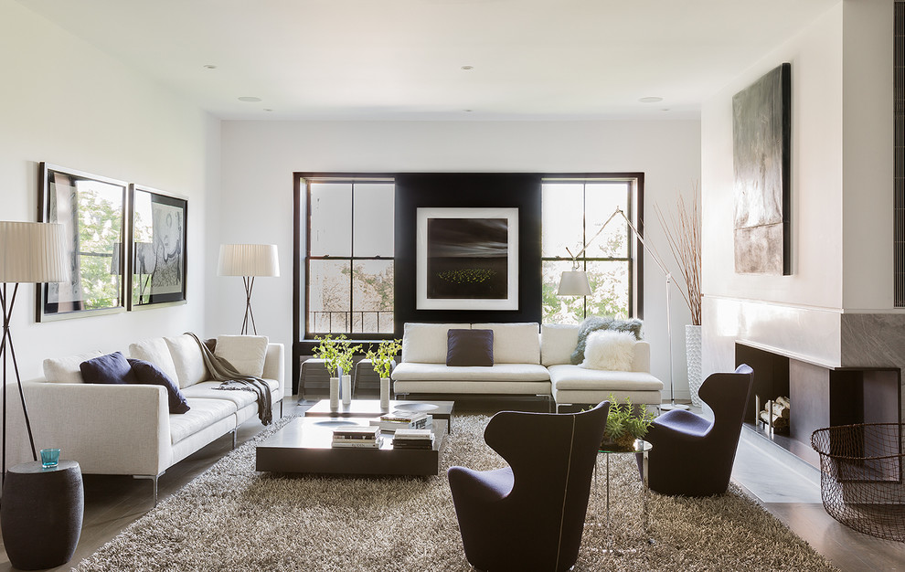 This is an example of a large contemporary formal enclosed living room feature wall in Boston with white walls, no tv, dark hardwood flooring, a standard fireplace and a concrete fireplace surround.