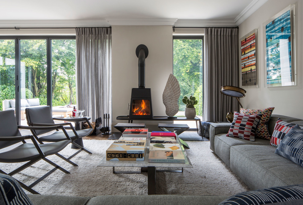 Example of a large trendy living room design in Buckinghamshire with a wood stove