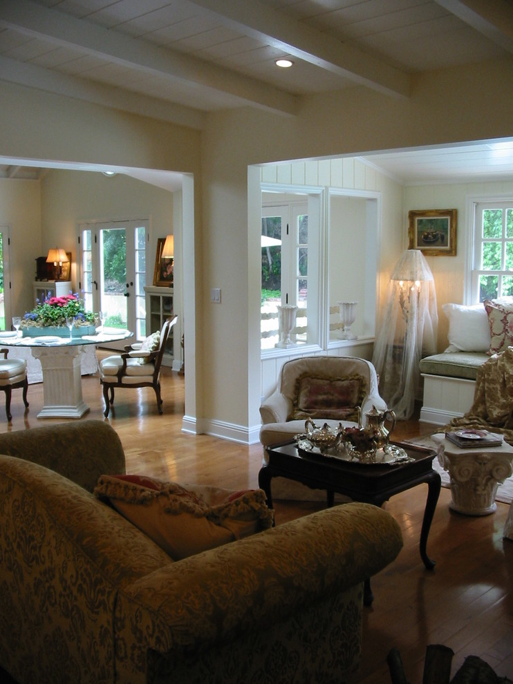 Foto di un soggiorno classico di medie dimensioni con pareti gialle, pavimento in legno massello medio e camino classico