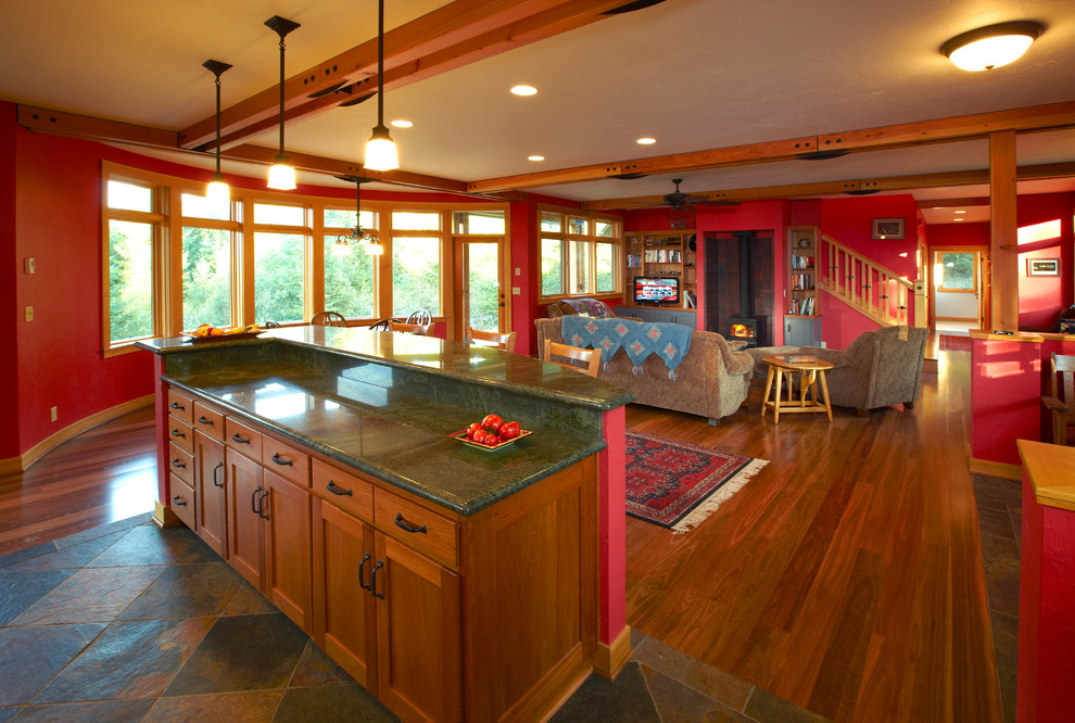 Exempel på ett mellanstort amerikanskt allrum med öppen planlösning, med röda väggar, mellanmörkt trägolv, en öppen vedspis, en spiselkrans i trä och en fristående TV