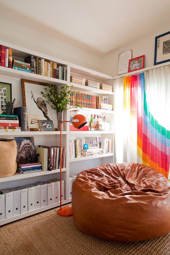На фото: гостиная комната в стиле фьюжн с с книжными шкафами и полками и белыми стенами с