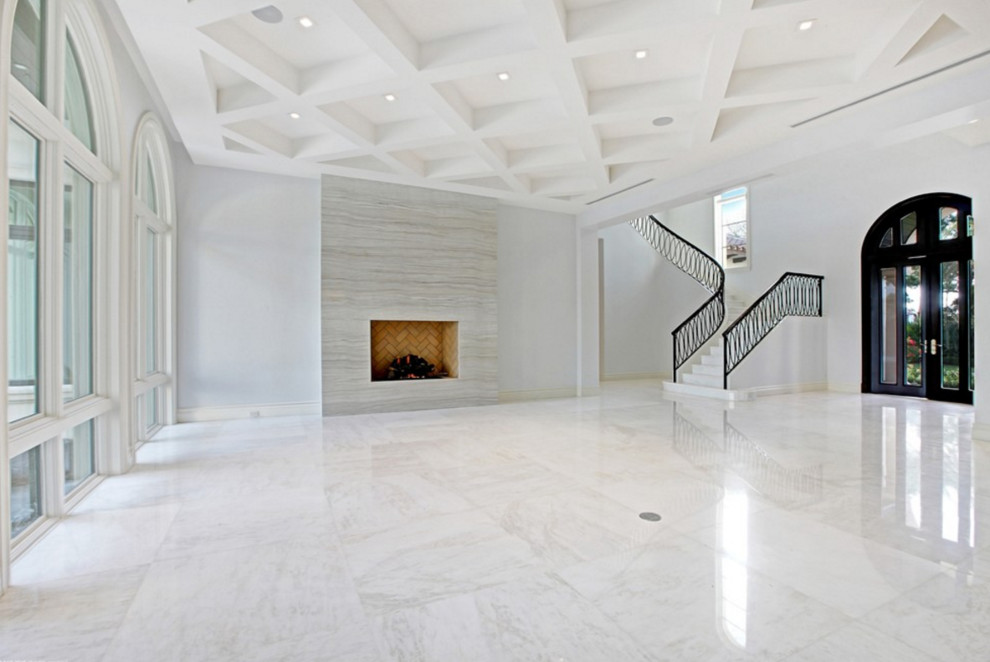 Стильный дизайн: большая парадная, открытая гостиная комната в средиземноморском стиле с серыми стенами, мраморным полом, стандартным камином и фасадом камина из камня без телевизора - последний тренд