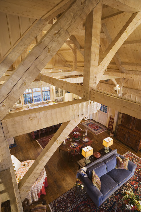 Foto de salón para visitas abierto de estilo americano grande con suelo de madera oscura, todas las chimeneas y marco de chimenea de piedra