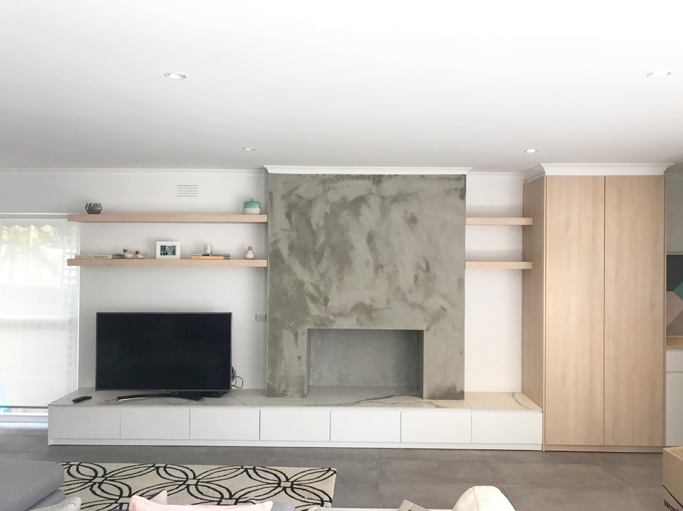Mittelgroßes, Repräsentatives, Offenes Modernes Wohnzimmer mit weißer Wandfarbe, Schieferboden, Kaminofen, Kaminumrandung aus Beton, freistehendem TV und grauem Boden in Melbourne
