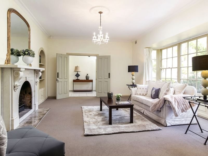 Aménagement d'un grand salon classique avec une salle de réception, un mur beige, une cheminée standard et un manteau de cheminée en pierre.