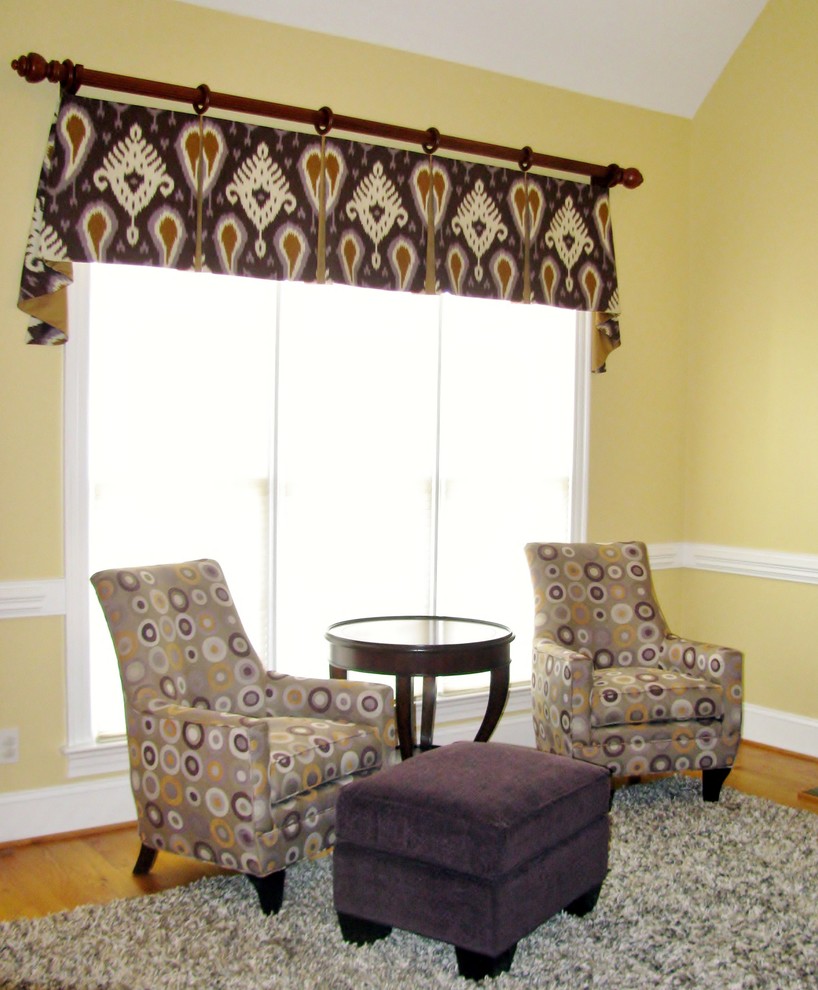 Mittelgroßes, Offenes Klassisches Wohnzimmer mit gelber Wandfarbe, hellem Holzboden, Kamin, Kaminumrandung aus Holz und TV-Wand in Raleigh
