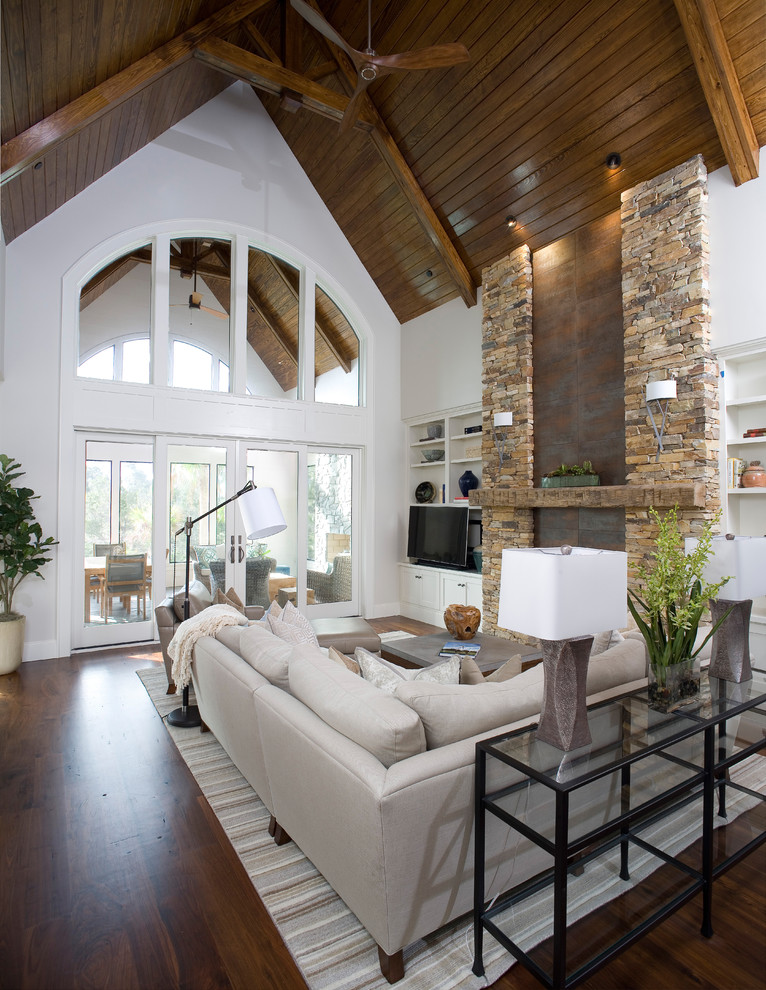Klassisches Wohnzimmer mit weißer Wandfarbe, braunem Holzboden, TV-Wand und braunem Boden in Charleston