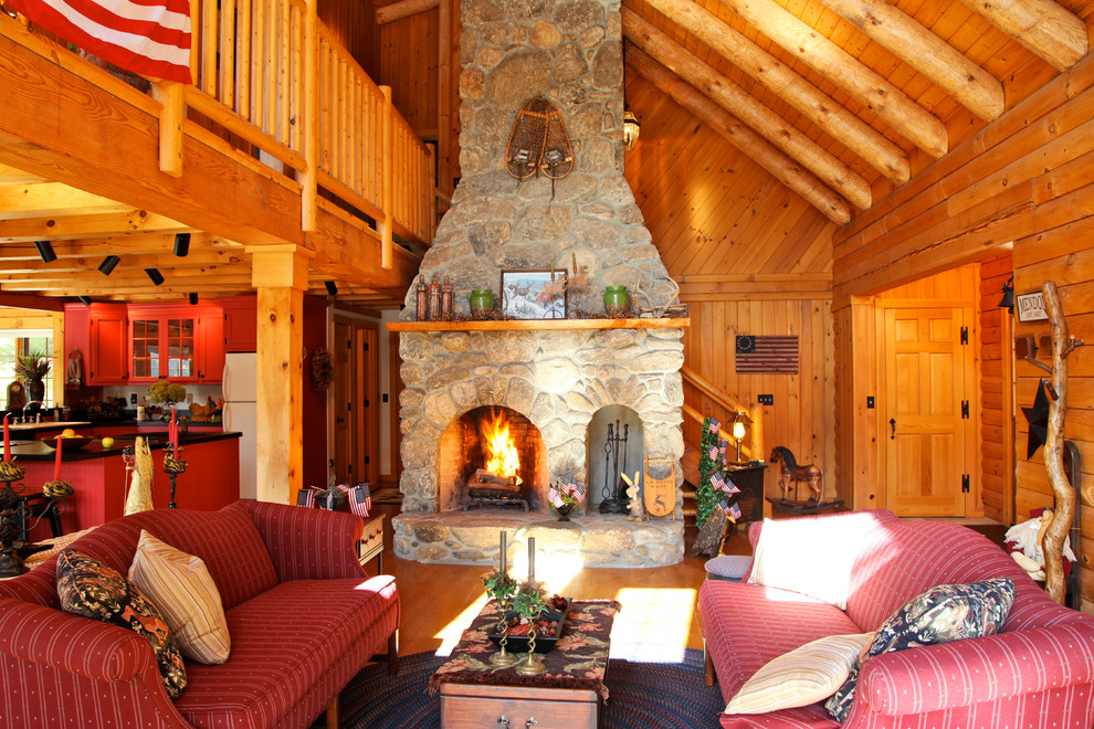 This is an example of a large rustic mezzanine living room in Boston with brown walls, light hardwood flooring, a standard fireplace, a stone fireplace surround and a freestanding tv.