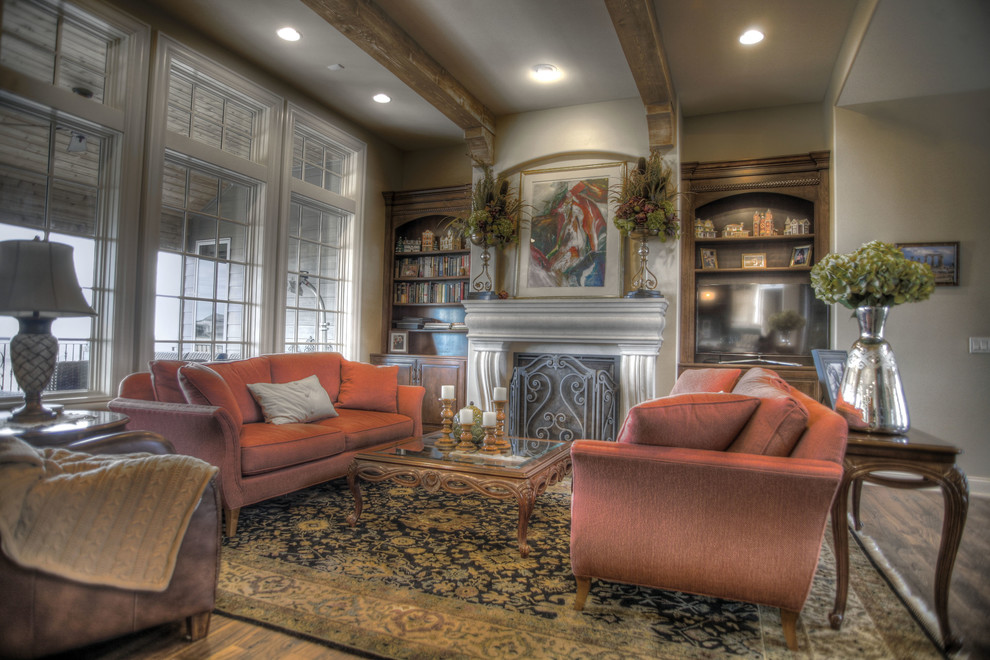 Example of a mid-sized mountain style formal and open concept medium tone wood floor and beige floor living room design in Omaha with beige walls, a standard fireplace, a concrete fireplace and no tv
