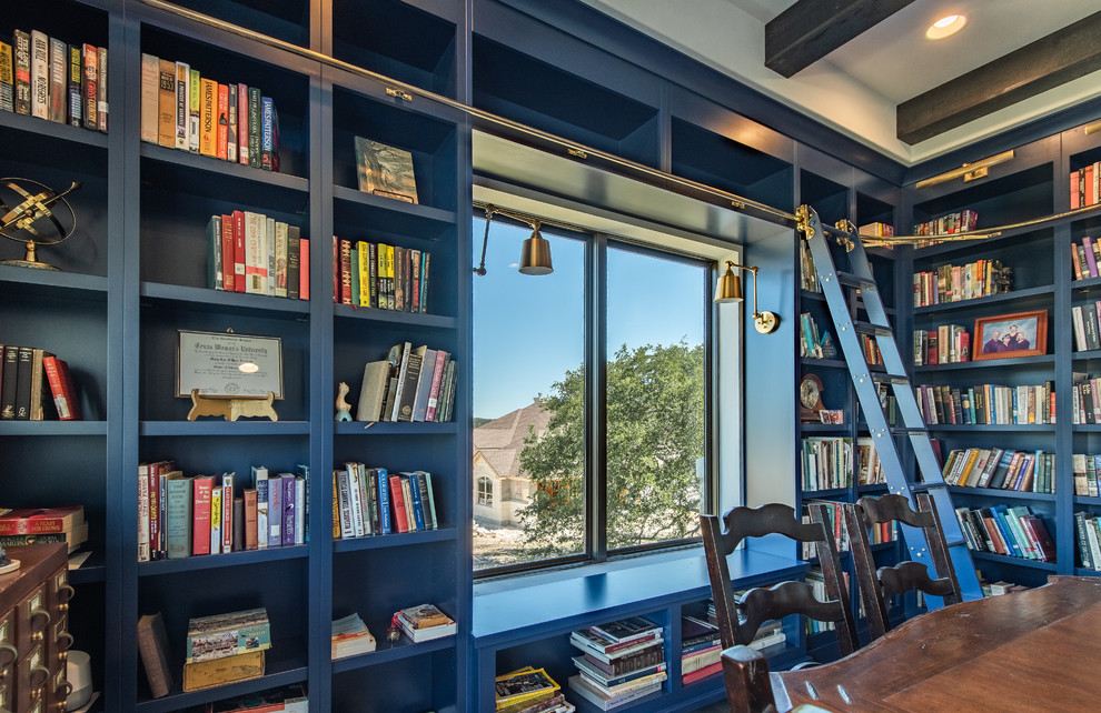 Modelo de biblioteca en casa cerrada actual de tamaño medio sin televisor y chimenea con paredes azules, suelo de madera en tonos medios y suelo marrón