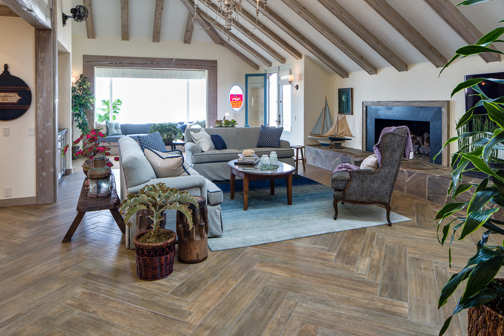Cette photo montre un grand salon bord de mer ouvert avec un sol en bois brun et une cheminée standard.