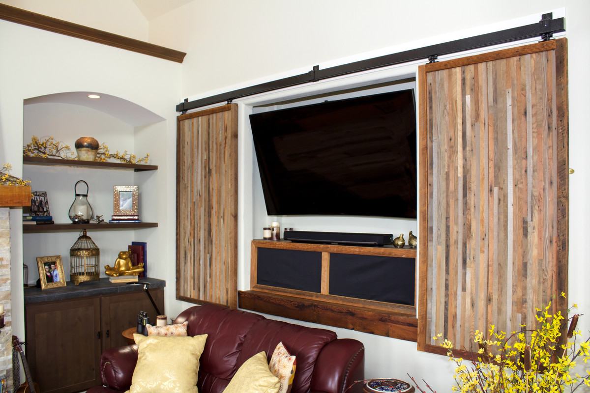 Réalisation d'un petit salon tradition ouvert avec un mur blanc, un sol en bois brun et un téléviseur dissimulé.
