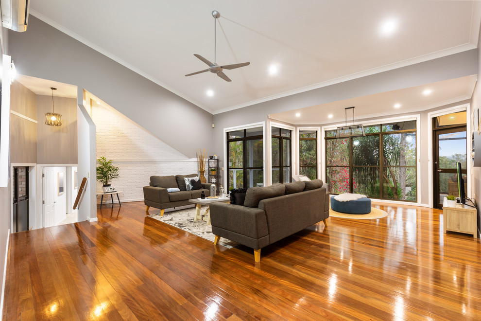 Geräumiges, Offenes Klassisches Wohnzimmer mit grauer Wandfarbe, braunem Holzboden und braunem Boden in Brisbane