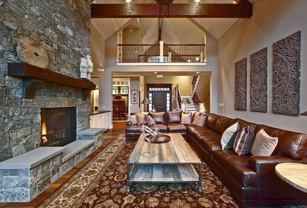 Стильный дизайн: открытая гостиная комната среднего размера в стиле кантри с коричневыми стенами, темным паркетным полом, стандартным камином и фасадом камина из камня - последний тренд