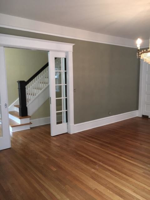 Imagen de salón abierto de estilo americano de tamaño medio sin chimenea con paredes beige y suelo laminado