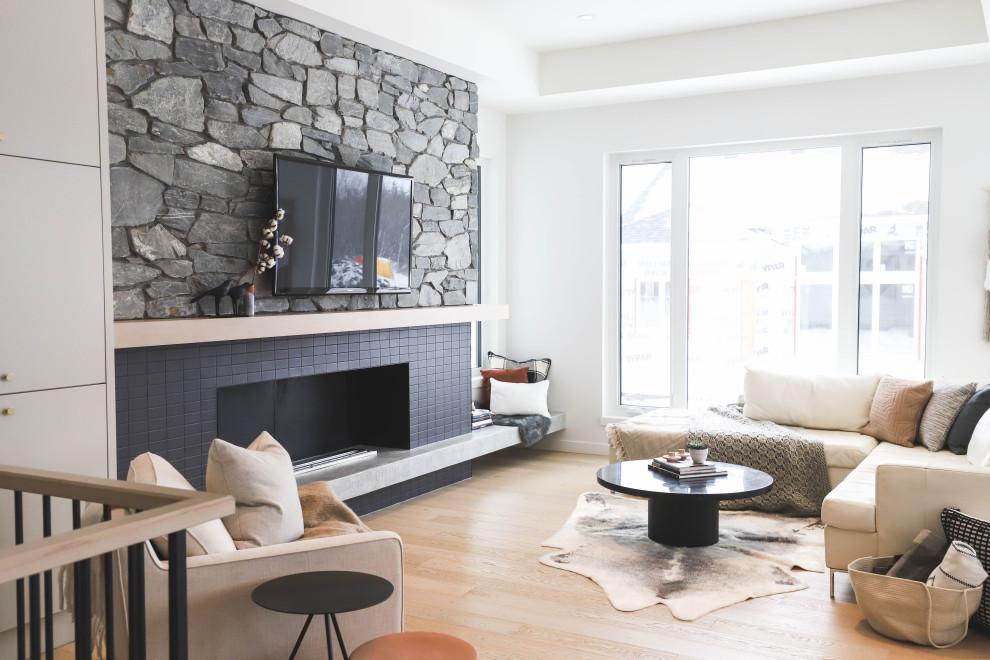 Ejemplo de salón escandinavo con paredes blancas, suelo de madera clara, todas las chimeneas, marco de chimenea de baldosas y/o azulejos, televisor colgado en la pared y casetón