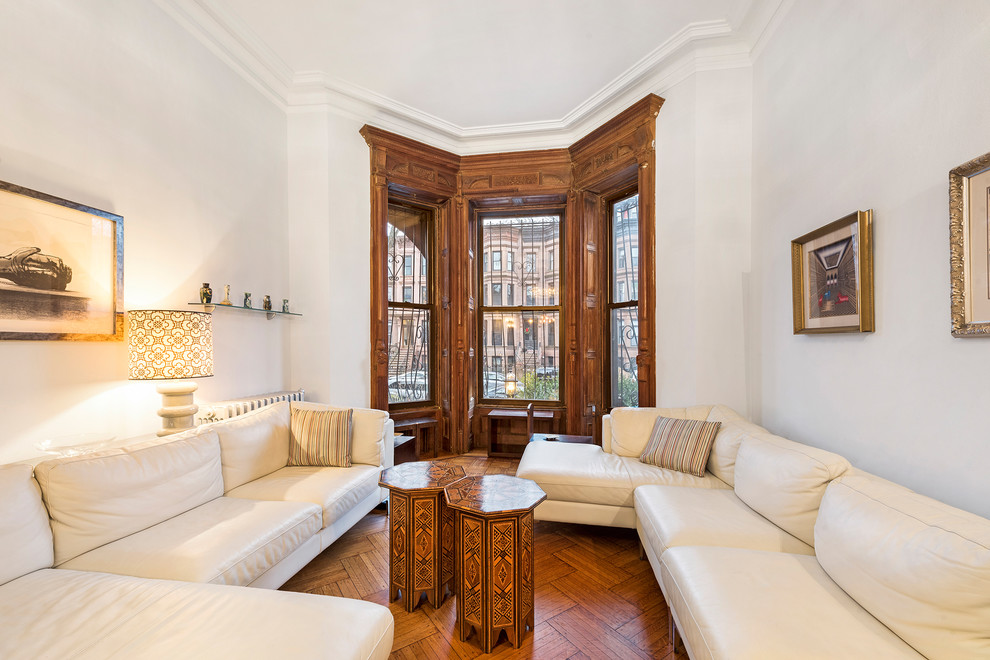 Klassisches Wohnzimmer mit grauer Wandfarbe, braunem Holzboden und braunem Boden in New York