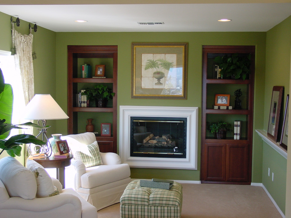 This is an example of a medium sized traditional formal enclosed living room in Los Angeles with green walls, carpet, a standard fireplace, a plastered fireplace surround and no tv.