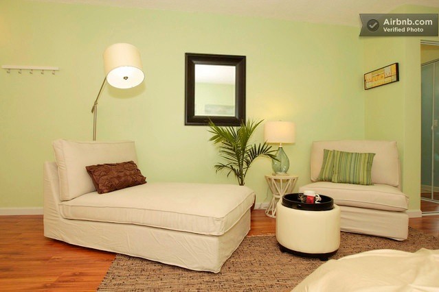 This is an example of a small contemporary open plan living room in Los Angeles with green walls and laminate floors.