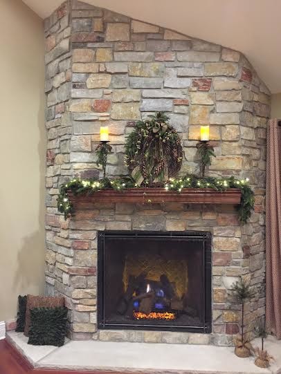 ミルウォーキーにある高級な中くらいなトラディショナルスタイルのおしゃれなリビング (ベージュの壁、濃色無垢フローリング、コーナー設置型暖炉、石材の暖炉まわり、テレビなし) の写真