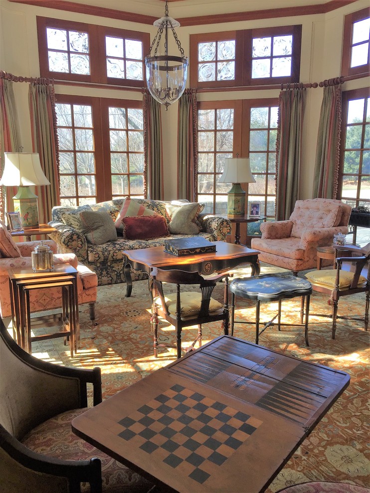 Exemple d'un grand salon chic ouvert avec une salle de réception, un mur beige, un sol en bois brun, une cheminée standard, un manteau de cheminée en pierre et un sol marron.