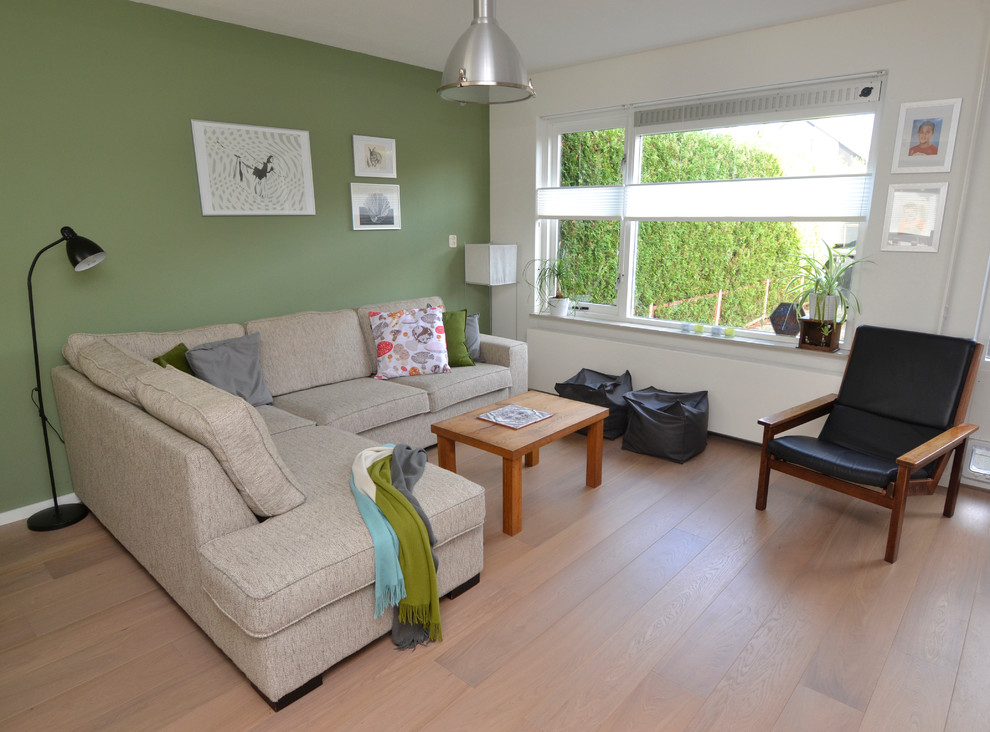 Esempio di un piccolo soggiorno contemporaneo chiuso con pareti verdi, parquet chiaro e TV autoportante