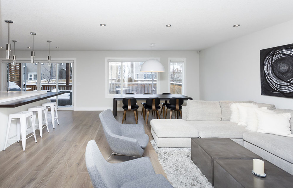 Mid-sized trendy open concept light wood floor and beige floor living room photo in Calgary with gray walls