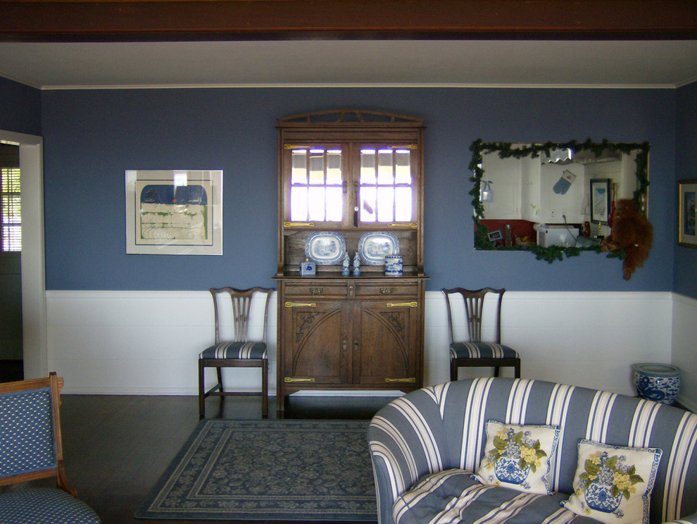 Aménagement d'un salon romantique avec un mur bleu et parquet foncé.