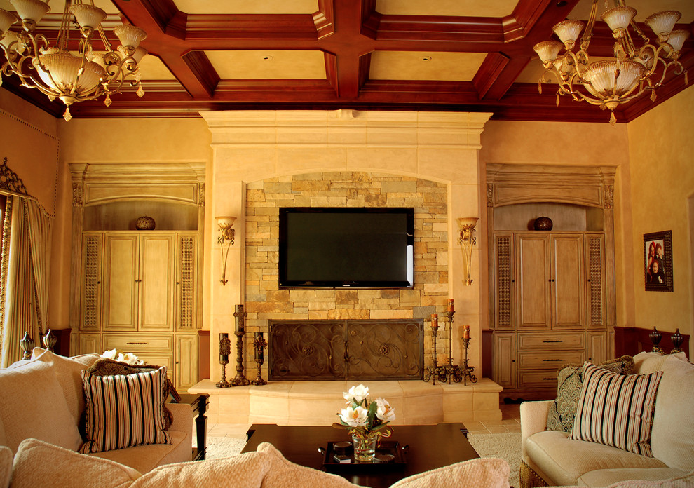 Mediterranes Wohnzimmer mit beiger Wandfarbe, Kamin und Kaminumrandung aus Stein in Los Angeles