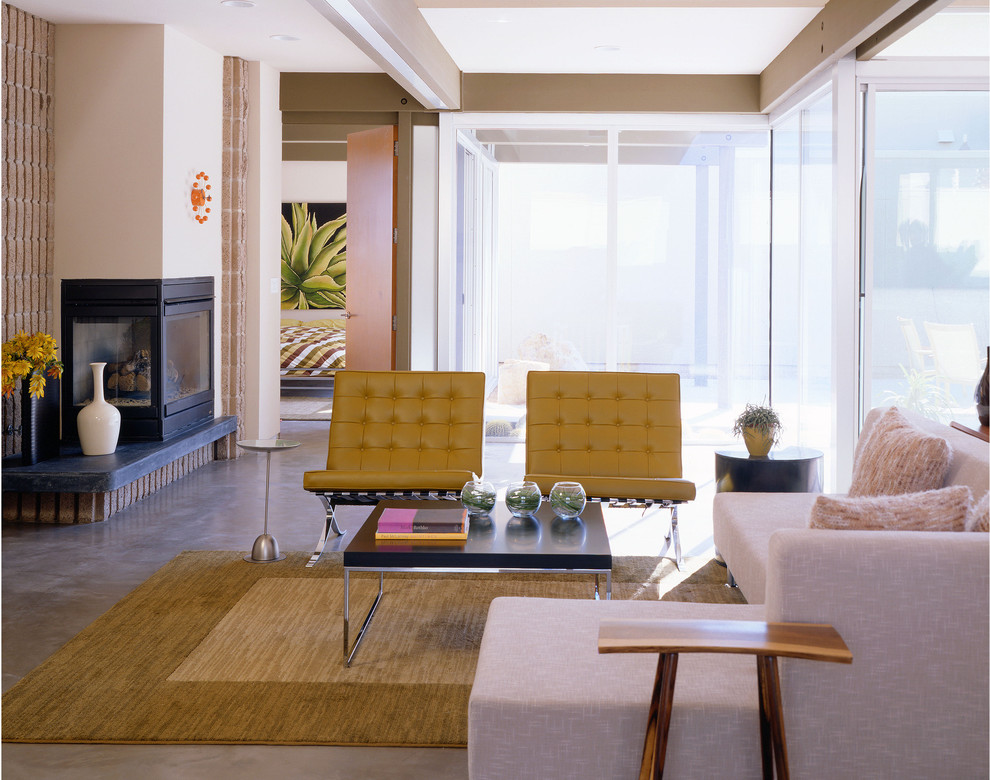 Источник вдохновения для домашнего уюта: гостиная комната в стиле модернизм с бежевыми стенами, бетонным полом, угловым камином и ковром на полу