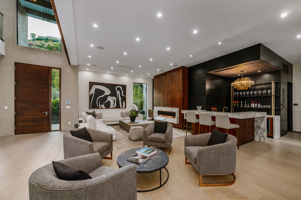 Идея дизайна: огромная открытая гостиная комната в современном стиле с домашним баром, белыми стенами, светлым паркетным полом, горизонтальным камином, фасадом камина из камня и коричневым полом без телевизора