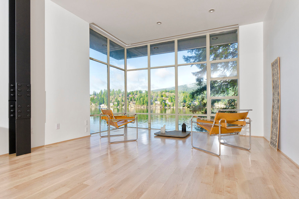 Modelo de salón abierto minimalista grande sin chimenea y televisor con paredes blancas y suelo de madera clara