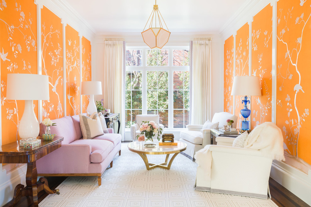 Réalisation d'un salon tradition avec un mur orange, parquet foncé et un sol marron.