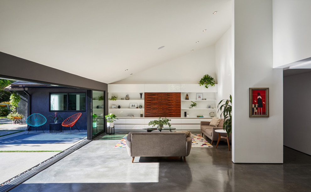 Immagine di un ampio soggiorno moderno aperto con sala formale, pareti bianche, pavimento in cemento, nessun camino, parete attrezzata e pavimento grigio