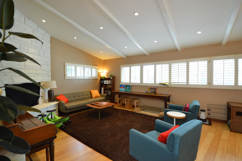 Foto di un soggiorno minimalista chiuso con sala formale, pareti beige, parquet chiaro, camino bifacciale e cornice del camino in mattoni
