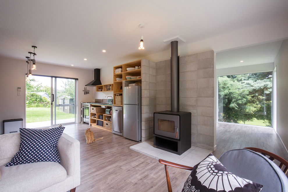 Offenes Modernes Wohnzimmer mit Vinylboden, Kamin und Kaminumrandung aus Beton in Wellington