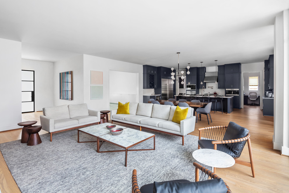 Idee per un grande soggiorno minimalista aperto con pareti bianche, parquet chiaro e pavimento marrone