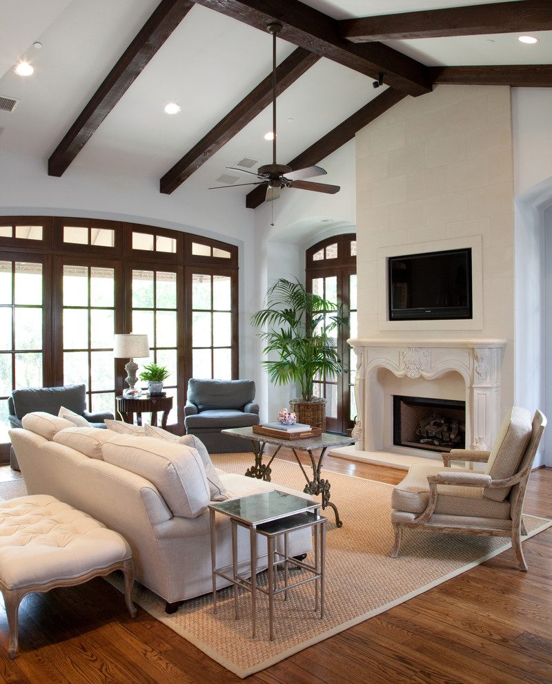 Mittelgroßes Klassisches Wohnzimmer mit braunem Holzboden, Kamin, TV-Wand und weißer Wandfarbe in Houston