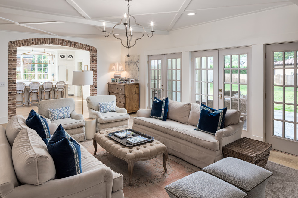 Example of a large classic enclosed light wood floor and beige floor living room design in Nashville with white walls, a standard fireplace, a brick fireplace and a wall-mounted tv