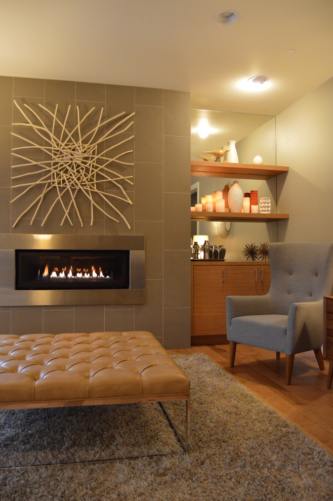 Foto de salón retro de tamaño medio con paredes grises, suelo de madera clara, chimenea lineal y marco de chimenea de baldosas y/o azulejos