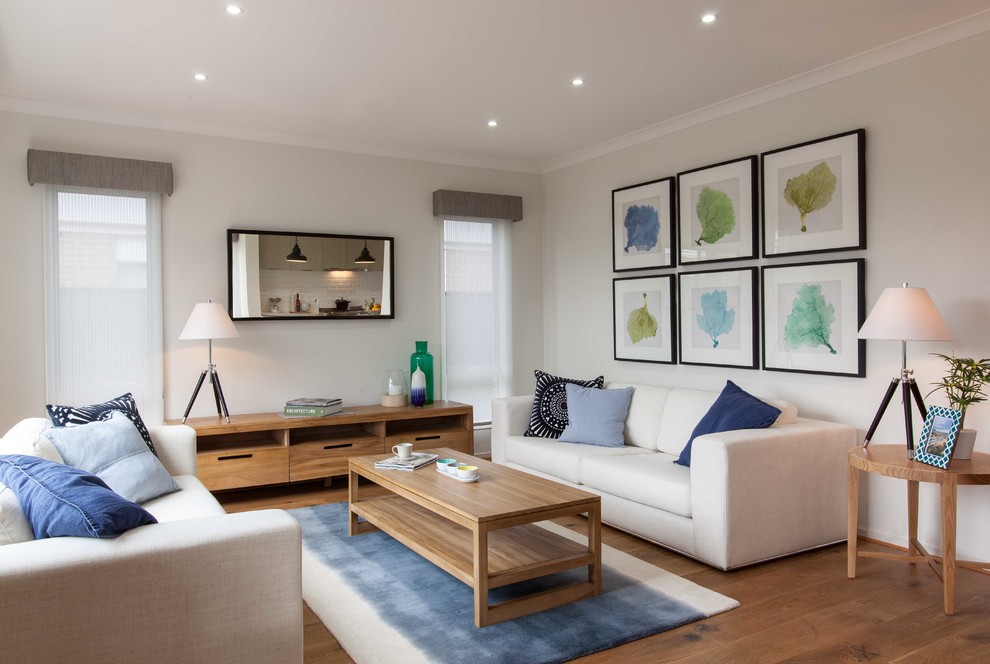 Living room - contemporary formal medium tone wood floor living room idea in Melbourne with white walls
