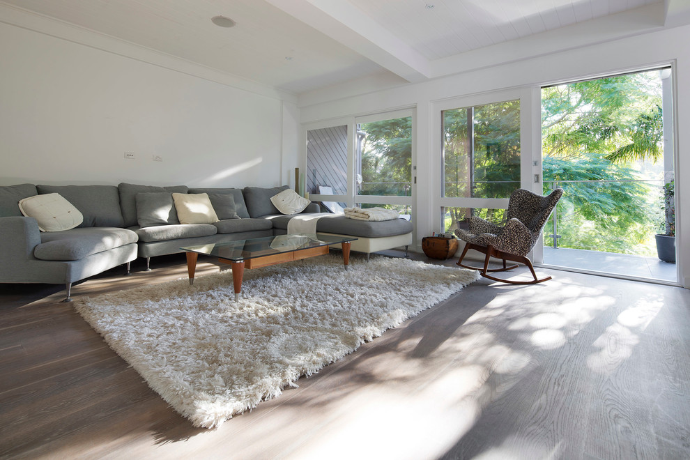 Esempio di un soggiorno design di medie dimensioni e aperto con pareti bianche, parquet chiaro, nessuna TV e pavimento marrone